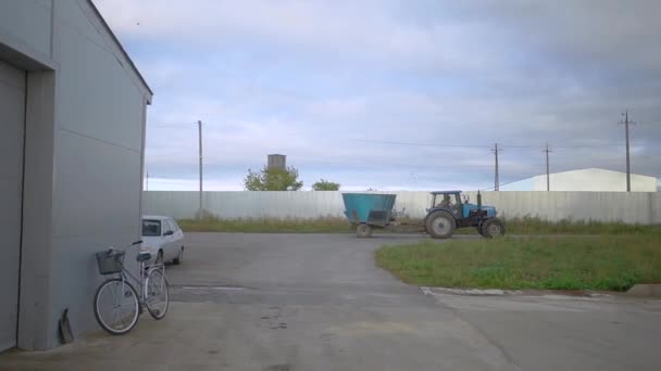 Traktorn står bredvid gården — Stockvideo