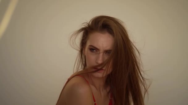 Una ragazza in biancheria intima rossa posa contro un muro bianco — Video Stock