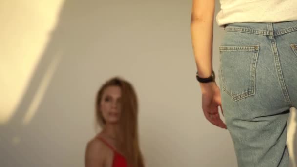 Ein Mädchen in roter Unterwäsche posiert vor einer weißen Wand — Stockvideo