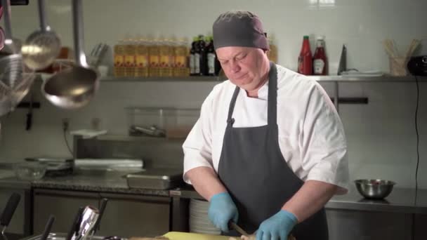 El cocinero corta el pastel de carne en el tablero — Vídeo de stock