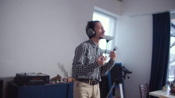 Een man met een hoofdtelefoon dansen en zingen — Stockvideo