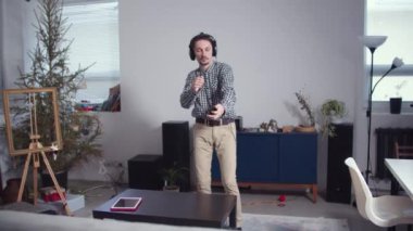 Kulaklıklı ve elinde telefon olan bir adam.