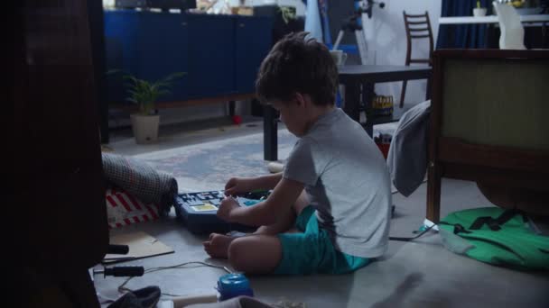 Copilul stă pe podea cu jucării — Videoclip de stoc