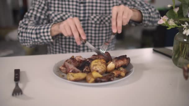Чоловік нарізає варене м'ясо на тарілці — стокове відео