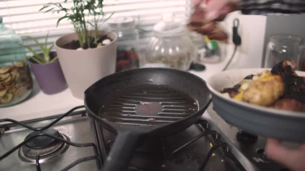 Чоловік кладе м'ясо на сковороду — стокове відео