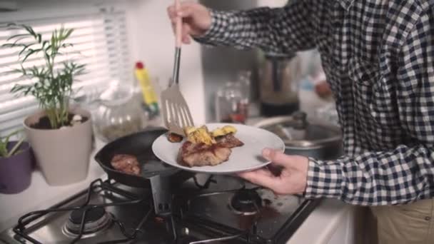 Чоловік кладе варену їжу з сковороди — стокове відео