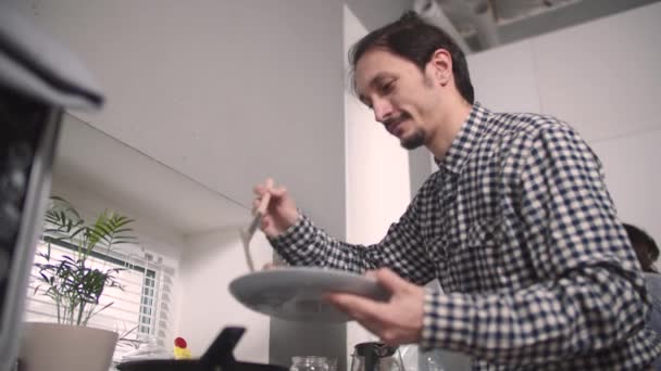 Ο τύπος βάζει φαγητό από το τηγάνι — Αρχείο Βίντεο