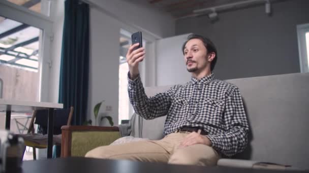 Killen sitter och pratar om videokommunikation — Stockvideo