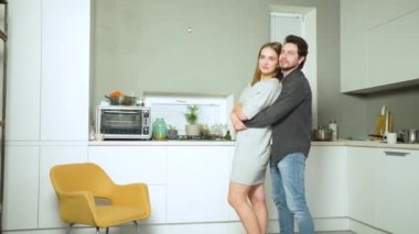 Genç çift sarılarak dans ediyor.