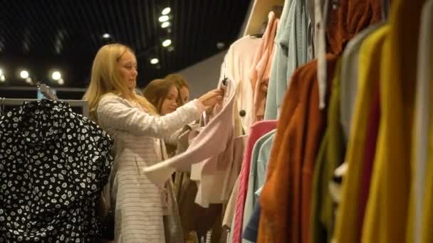 Trois copines choisissent des vêtements dans le magasin — Video
