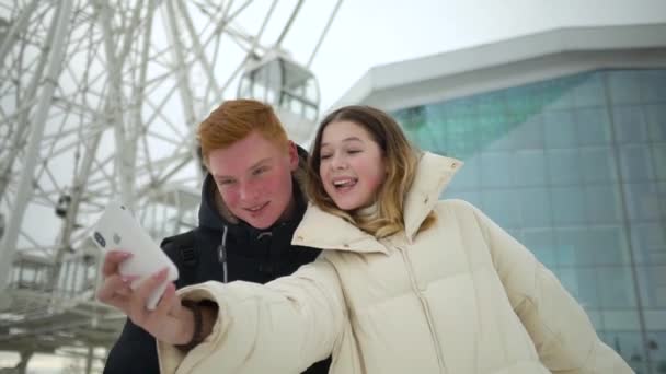 Egy fiú és egy lány szelfit csinálnak az utcán. — Stock videók