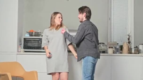 Девушка с парнем, танцующим на кухне — стоковое видео