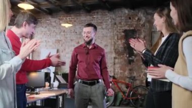 Ofis çalışanları meslektaşlarını tebrik ediyor.