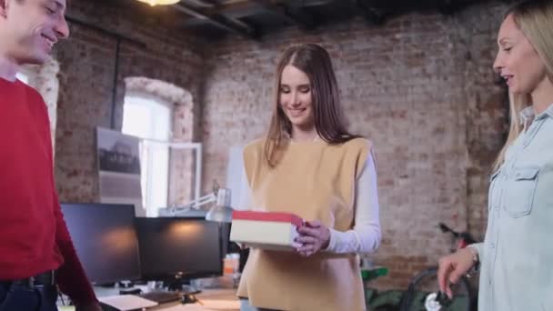 Kantoormedewerker opent vrolijk in totaal een geschenk — Stockvideo