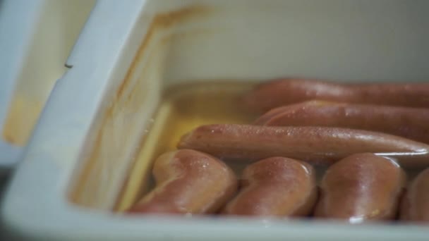Salsichas cozidas jazem em utensílios de plástico — Vídeo de Stock