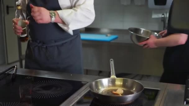 Chef tuesta langostinos en una sartén con fuego — Vídeo de stock