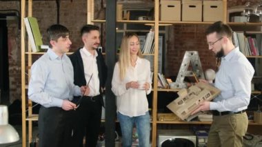 Ofis personeli binanın planlarını tartışıyor ve gözden geçiriyor.