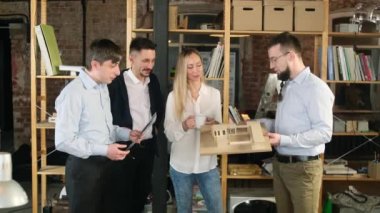 Ofis personeli binanın planlarını tartışıyor ve gözden geçiriyor.