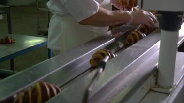 Hazır kruvasanlar taşıma bandında hareket ediyor.