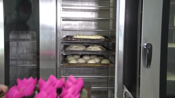 パン屋はオーブンで生地のペストリーを置く — ストック動画