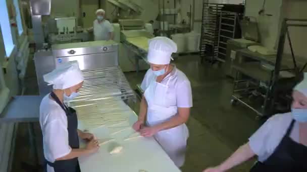 Meesters in de bakkerij draaien uit deeg croissants — Stockvideo