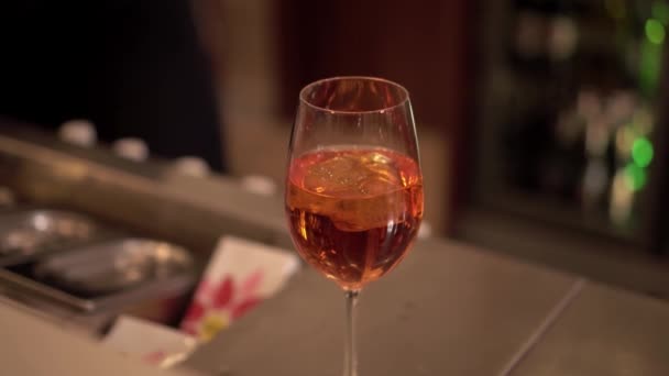 Professional barkeeper puts small orange slice on glass — Stock Video