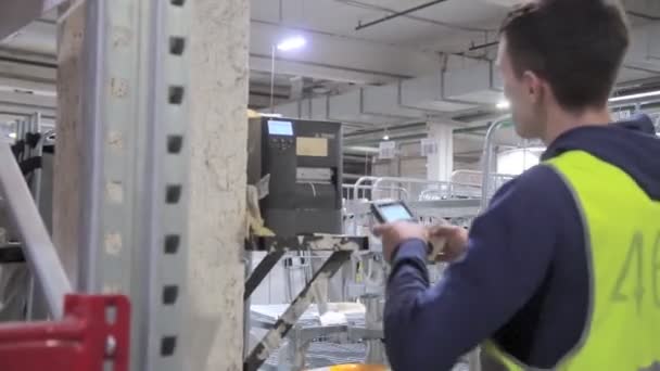 De bedrijfsleider in het magazijn controleert de inventaris door de informatie te scannen — Stockvideo