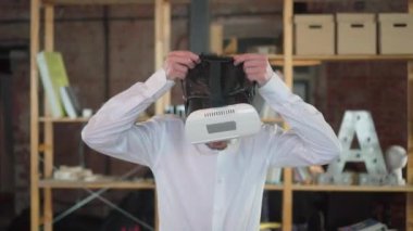 Guy with beard and moustache puts on virtual reality headset