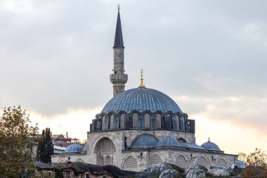 Türkiye 'nin İstanbul kentindeki Osmanlı tarzı camide zarif bir taş kubbe, kemerli pencereler ve ince bir minare sergileniyor. Sakin gökyüzü ve ılık ışık seyahat, din, kültür, tarih ve mimari kavramlara uygun zamansız bir sahne yaratır..