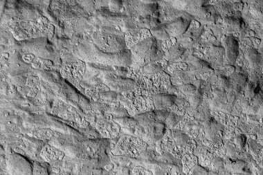 Yüksek çözünürlüklü siyah ve beyaz beton duvar dokusu çatlamış çimento, gömülü taşlar ve yıpranmış sert yüzey. Güçlü detay ve doğal şablona sahip endüstriyel grunge arka planı, mimari veya inşaat kavramları için mükemmel..