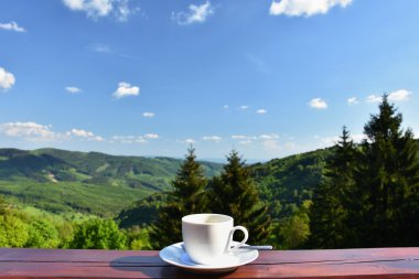 Bir güzel dağ manzara arka plan ile kahve sabah fincan. Dinlenme ve rekreasyon tatil.