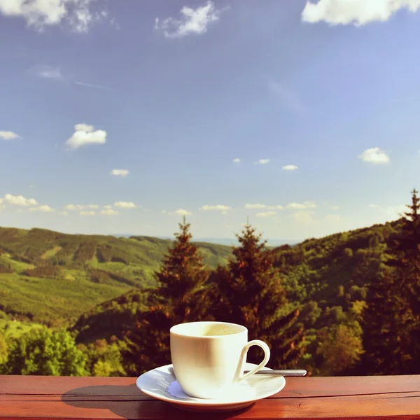 Morning cup of coffee with a beautiful mountain landscape background