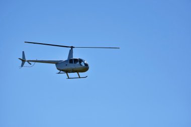 Mavi gökyüzüne doğru uçan helikopter.