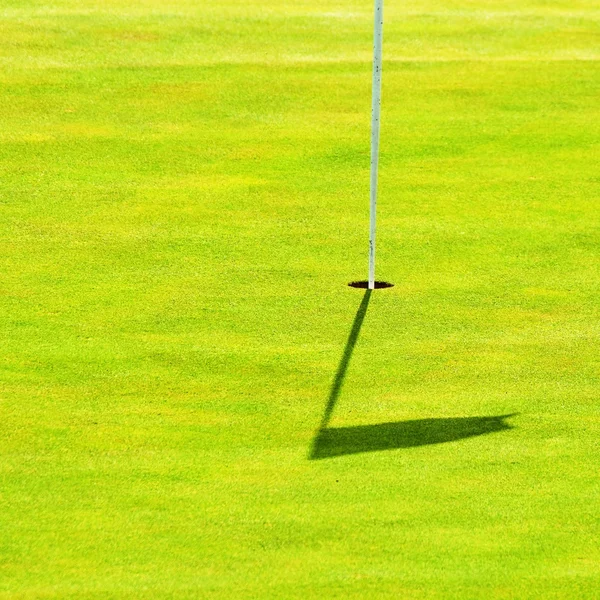 Bonito campo de golf en un día soleado de verano. Agujero con bandera. Popular deporte al aire libre . — Foto de Stock