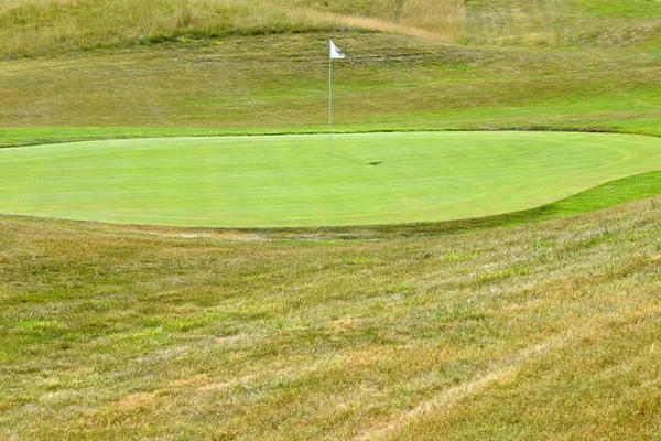 Belo campo de golfe num dia ensolarado de verão. Buraco com uma bandeira. Desporto ao ar livre popular . — Fotografia de Stock