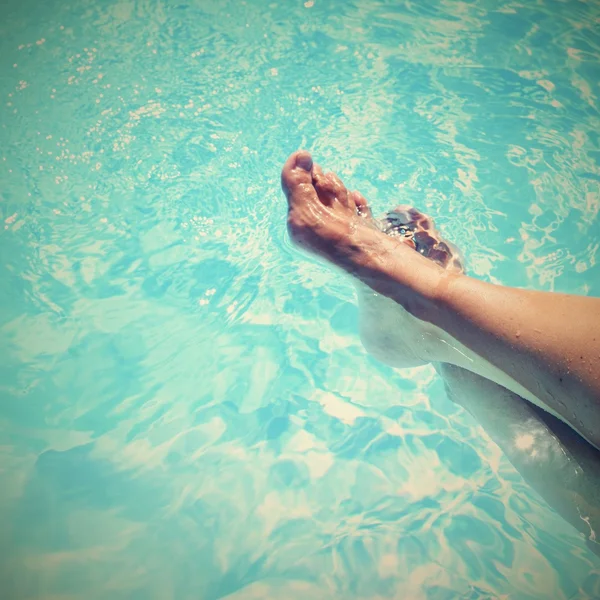 Ноги в басейні з чистою водою. Літній фон для подорожей та відпочинку . — стокове фото
