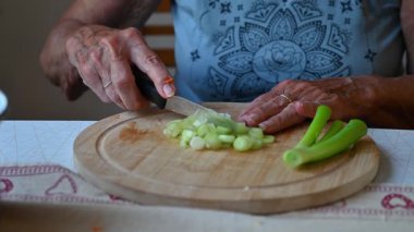 Mutfakta sebze doğrayan ve hazırlayan bir kadın. Yemek ve yemek hazırlama kavramı.