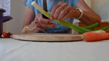 Mutfakta sebze doğrayan ve hazırlayan bir kadın. Yemek ve yemek hazırlama kavramı.