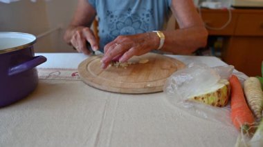 Mutfakta sebze doğrayan ve hazırlayan bir kadın. Yemek ve yemek hazırlama kavramı.