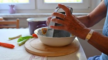 Mutfakta sebze doğrayan ve hazırlayan bir kadın. Yemek ve yemek hazırlama kavramı.