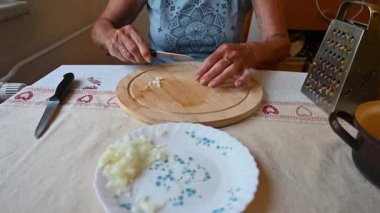 Mutfakta sebze doğrayan ve hazırlayan bir kadın. Yemek ve yemek hazırlama kavramı.