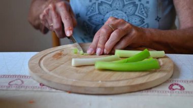Mutfakta sebze doğrayan ve hazırlayan bir kadın. Yemek ve yemek hazırlama kavramı.