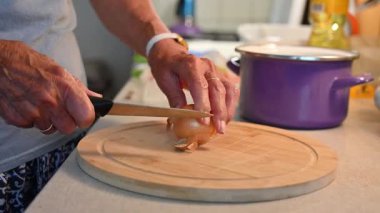 Mutfakta sebze doğrayan ve hazırlayan bir kadın. Yemek ve yemek hazırlama kavramı.