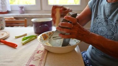 Mutfakta sebze doğrayan ve hazırlayan bir kadın. Yemek ve yemek hazırlama kavramı.