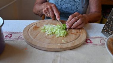 Mutfakta sebze doğrayan ve hazırlayan bir kadın. Yemek ve yemek hazırlama kavramı.