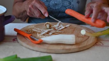 Mutfakta sebze doğrayan ve hazırlayan bir kadın. Yemek ve yemek hazırlama kavramı.