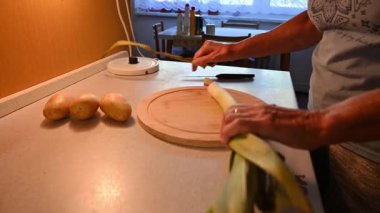 Mutfakta sebze doğrayan ve hazırlayan bir kadın. Yemek ve yemek hazırlama kavramı.