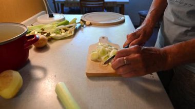 Mutfakta sebze doğrayan ve hazırlayan bir kadın. Yemek ve yemek hazırlama kavramı.