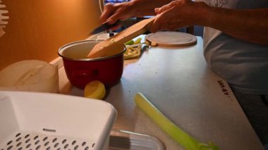 Mutfakta sebze doğrayan ve hazırlayan bir kadın. Yemek ve yemek hazırlama kavramı.