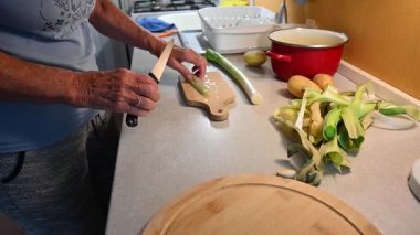 Mutfakta sebze doğrayan ve hazırlayan bir kadın. Yemek ve yemek hazırlama kavramı.